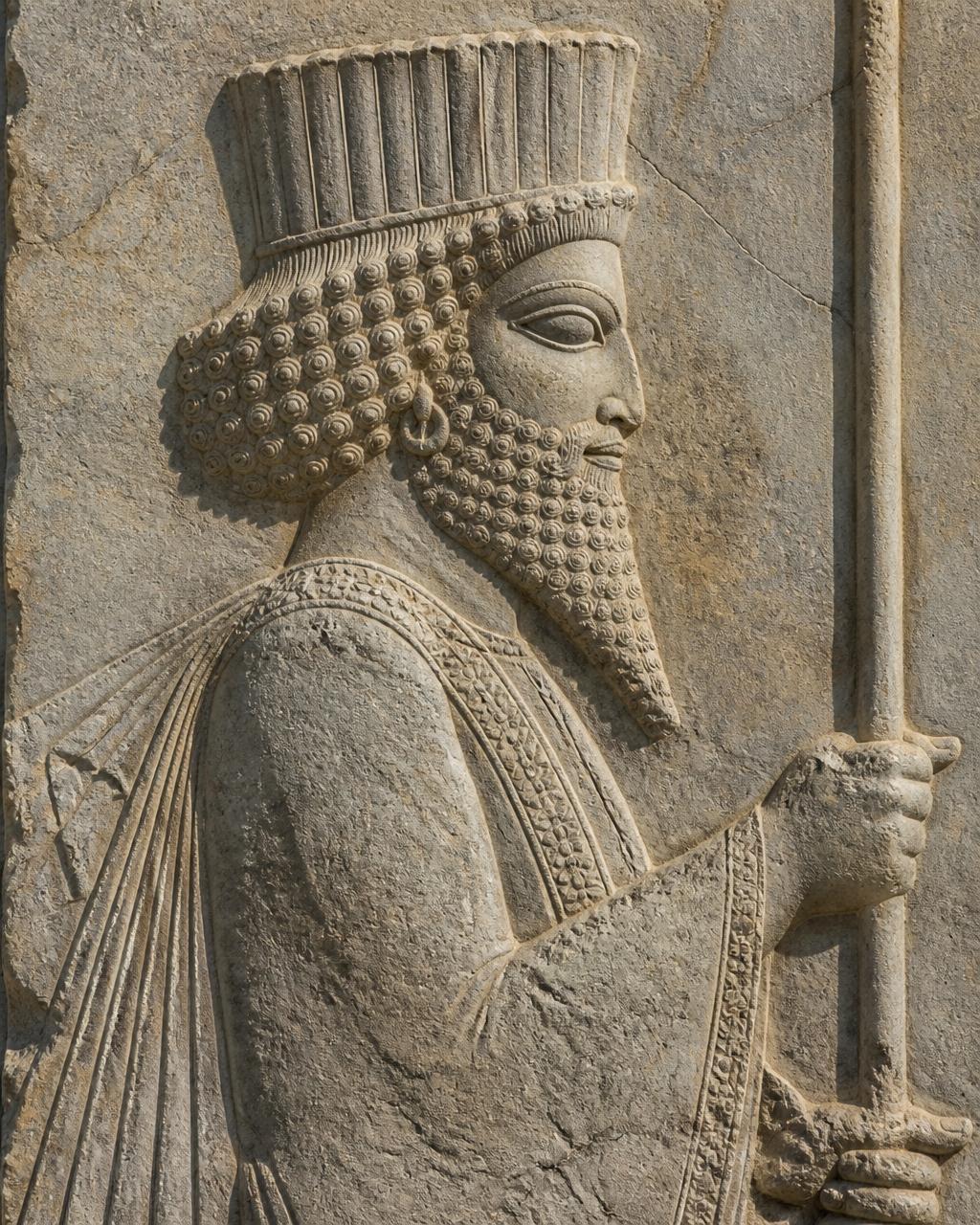 Detailed Persian bas-relief carving of a processional figure in stone